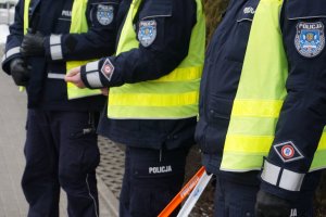 policjanci trzymają w ręce elementy odblaskowe