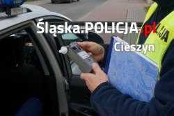 policjant patrzy na urządzenie pomiarowe w ręce