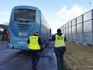 dzień, parking, policjant i inspektor transportu drogowego idą do autobusu