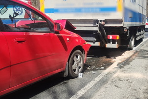 grafika-miejsce zdarzenia, dzień, pojazd ciężarowy a za nim samochód osobowy, służby ratownicze, policja, straż pożarna, pogotowie