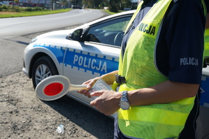 dzień, policjantka , droga, kobieta trzyma w ręku tarczę do zatrzymywania pojazdów