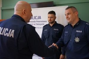 Komendant Powiatowy Policji w Cieszynie inspektor Jacek Stelmach wręcza rozkazy i gratuluje ściskając rękę