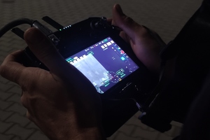 grafika,noc,mężczyzna trzyma w dłoniach pilota drona