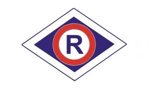 grafika- symbol policji ruchu drogowego-litera R na białym tle otoczona czerwoną obwódką, wpisana w romb