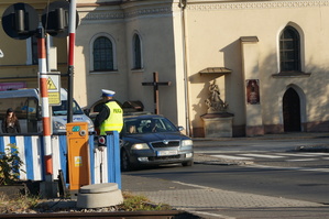 dzień, słonecznie, policjanci rozdają ulotki pieszych i kierowcom