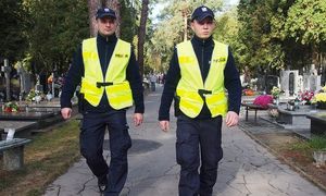 grafika-dzień, cmentarz, policjant i policjantka idą obok siebie w mundurze