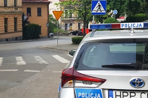 zdjęcie-dzień, policyjny radiowóz przed przejściem dla pieszych, widoczny znak przejścia dla pieszych