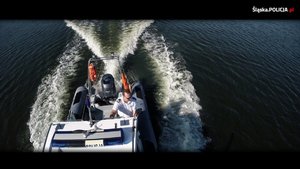 grafika-dzień, woda, policjanci płyną łodzią motorową