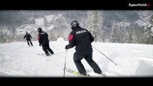 grafika-dzień, zima, policjanci jadą na nartach
