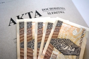 zdjęcie-teczka akt dochodzenia, na niej 5 banknotów 200 zł