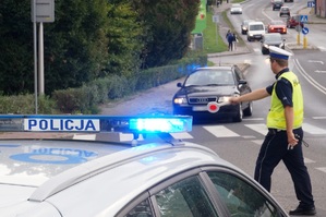 zdjęcie-dzień, policjant wskazuje kierowcy gdzie ma się zatrzyzmać