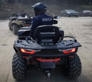 zdjęcie-dzień, parking. policjant siedzi na quadzie