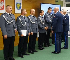 zdjęcie-komendanci gratulują policjantom ściskając ich dłoń, policjanci ustawieni w szeregu obok siebie