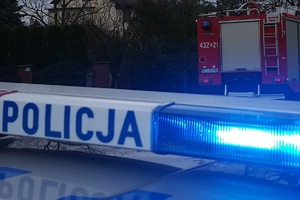 zdjęcie-niebieski sygnał uprzywilejowania na policyjnym radiowozie, napis policja, zmierzch