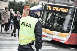 zdjęcie-dzień ,policjant, autobus z napisem CMENTARZ