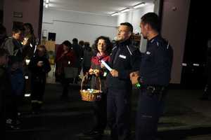 policjanci i burmistrz wręczają odblaski, noc, oświetlenie sztuczne