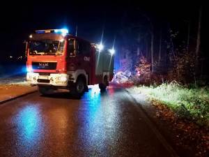 zdjęcie miejsca zdarzenia-noc samochód policji i straży pożarnej z włączonymi światłami uprzywilejowania