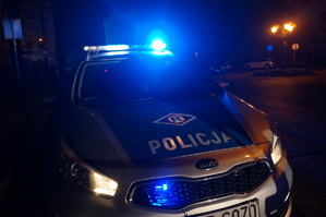 zdjęcie-radiowóz policji z włączonymi niebieckimi światłami uprzywilejowania, noc
