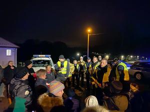 zdjęcie- noc, policjanci wręczają odblaski