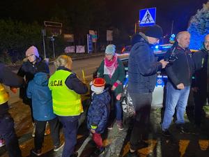 zdjęcie- noc, policjanci wręczają odblaski