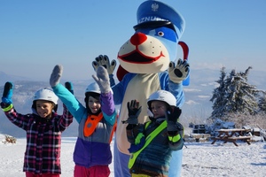 zdjęcie-zima, dzień, słonecznie, maskotka Sznupek i dzieci pozują do zdjęcia w górach