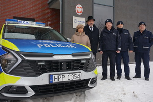 zdjęcie- zima, śnieg, dzień, nowy radiowóz, przedstawiciele samorządu oraz policjanci obok radiowozu
