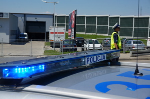 dzień ,sygnały radiowozu, w tle policjant, słonecznie