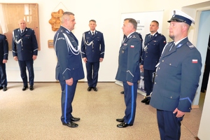 dzień, świetlica, policjanci w mundurach, dowódca uroczystości składa meldunek Komendantowi Wojewódzkiemu