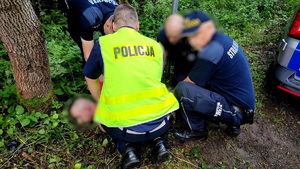 policjanci i strażnik miejski przytrzymują zatrzymanego mężczyznę, który leży