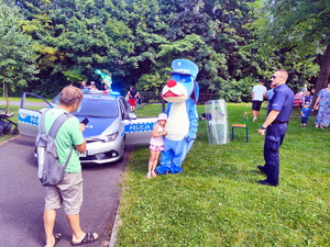 dziecko pozujące do zdjęcia wraz z maskotką śląskiej policji