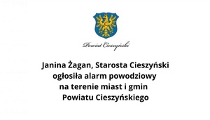 Grafika informacyjna z herbem Powiatu Cieszyńskiego i tekstem: &quot;Janina Żagan, Starosta Cieszyński ogłosiła alarm powodziowy na terenie miast i gmin Powiatu Cieszyńskiego.&quot;I