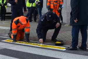 Komendant Bloch maluje napisy odłóż telefon i żyj na przejściu dla pieszych