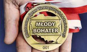 na dłoni medal z napisem młody bohater