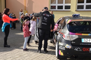 radiowóz policji i straży pożarnej oraz samochód rajdowy braci Szeja na placu przy szkole