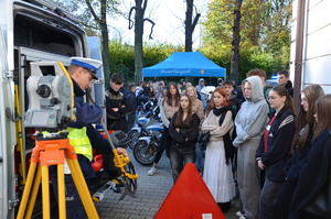 zdjęcie-plac, dzień, młodzież przygląda się i słucha co mówią i pokazują policjanci