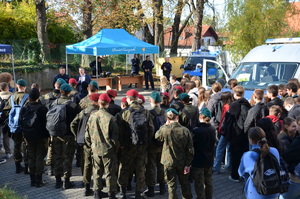 zdjęcie-plac, dzień, młodzież przygląda się i słucha co mówią i pokazują policjanci