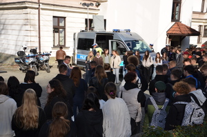 zdjęcie-plac, dzień, młodzież przygląda się i słucha co mówią i pokazują policjanci