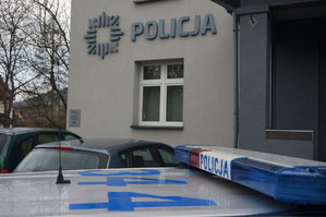 radiowóz, w tle budynek z napisem policja, dzień