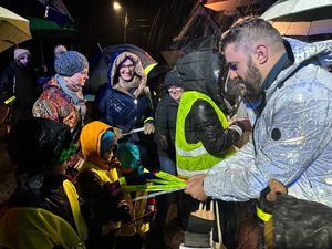 zdjęcie- noc, policjanci wręczają odblaski, ludzie pozują do zdjęć