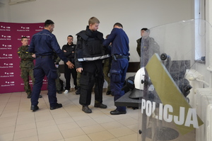 policjanci przemawiają do zgromadzonych na spotkaniu uczniów