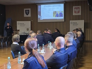 zaproszeni gości siedzą w sali konferencyjnej i oglądają prezentację