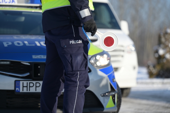 policjant z tarczą do zatrzymywania pojazdów, dzień, droga