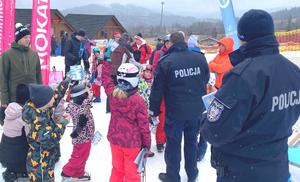 policjanci rozmawiają z dziećmi na stoku, śnieg, zima, pochmurno