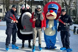 dzień, lodowisko, policjanci na łyżwach oraz maskotki pozują do zdjecia