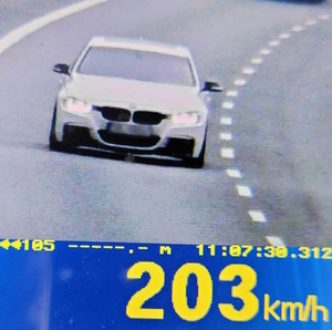 samochód w obiektywie fotoradaru, prędkość 203 kilometry na godzinę, dzień, droga