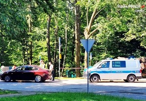 dzień, droga, słonecznie, pojazd osobowy oraz samochód policji za nim, kontrola ruchu