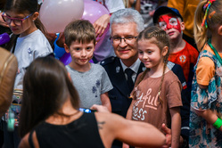 generał nadinspektor Mariusz Krzystyniak w towarzystwie dzieci pozuje do zdjecia