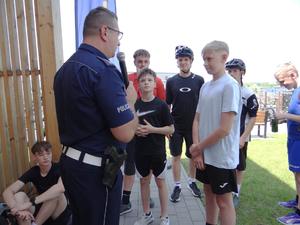 policjanci rozmawiają z młodzieżą, słonecznie, park