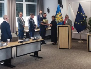 sala sesyjna, policjant odbiera gratulacje