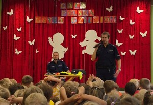 sala, dzieci siedzą i oglądają wystąpienie policjantów